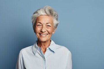 Portrait of a cheerful elderly woman in her 90s wearing a simple cotton shirt against a solid color backdrop. AI Generation