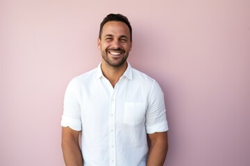 Portrait of a cheerful man in his 30s wearing a simple cotton shirt against a solid pastel color...