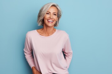 Portrait of a happy woman in her 40s sporting a comfortable hoodie against a solid pastel color wall. AI Generation - obrazy, fototapety, plakaty
