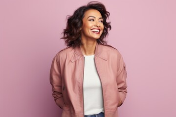 Obraz premium Portrait of a cheerful indian woman in her 40s wearing a trendy bomber jacket against a solid pastel color wall. AI Generation