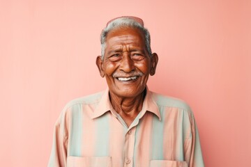 Portrait of a glad indian elderly man in his 90s sporting a breathable hiking shirt against a solid...