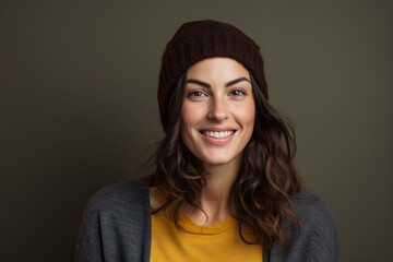 Portrait of a grinning woman in her 30s donning a warm wool beanie against a blank studio backdrop. AI Generation
