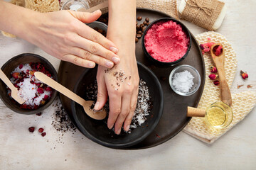 A woman's hand applies a natural coffee scrub. Skin care cosmetics. Beauty concept