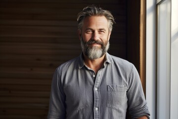 Obraz premium Portrait of a satisfied man in his 50s dressed in a relaxed flannel shirt against a light wood minimalistic setup. AI Generation