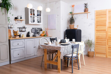 a wooden kitchen table on the background of a kitchen with a black refrigerator. kitchen decoration in the photo studio. at the set kitchen table with appliances and plates for photo shoots