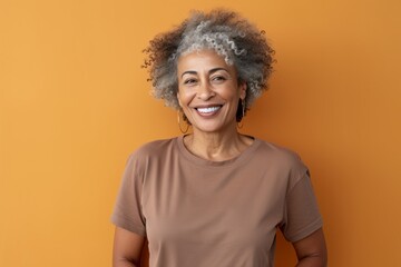 Portrait of a grinning afro-american woman in her 60s wearing a sporty polo shirt against a light wood minimalistic setup. AI Generation