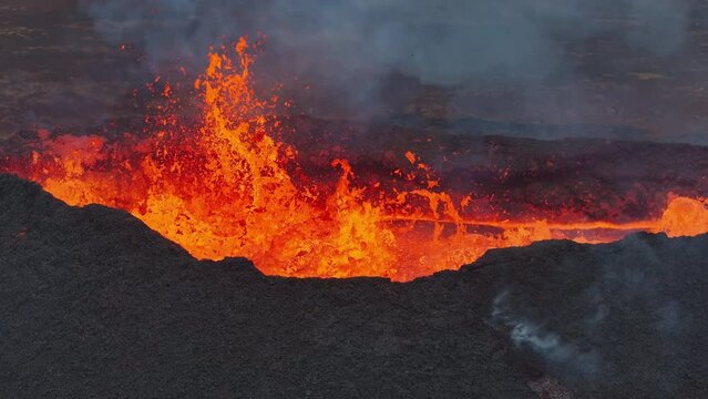 Close up view of active volcanic crater eruption. Hot lava and magma splashing out of crater. Tourist attraction in Iceland Litli-Hr&uacute;tur eruption 2023. Beautiful and dangerous disaster.