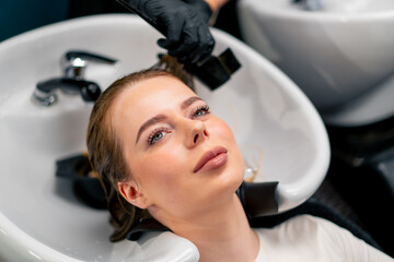 close-up of a hairdresser applying paint to a client's wet hair in a beauty salon makeover