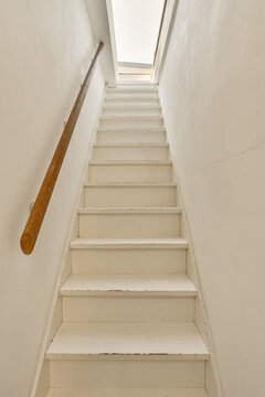 Minimalist white staircase with wooden handrail