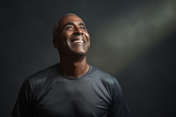 Obraz premium Portrait of a joyful man in his 50s sporting a breathable mesh jersey against a bare monochromatic room. AI Generation