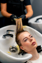 close-up of a hairdresser applying paint to a client's wet hair in a beauty salon makeover
