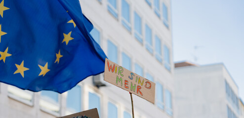 Flag of European Union and protest sign at demonstration against far-right political party AfD,...