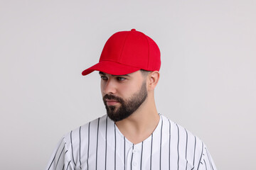 Man in stylish red baseball cap on white background