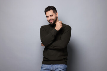 Obraz premium Happy man in stylish sweater on grey background