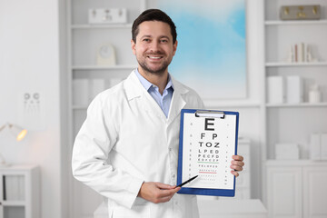 Fototapeta na wymiar Ophthalmologist pointing at vision test chart in clinic
