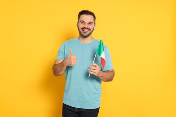 Man with flag of Italy showing thumb up on yellow background