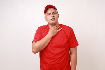 Asian delivery guy employee man in red had a sore throat and touched his throat. Difficult to swallow