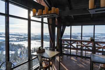 cafe interior with panoramic windows overlooking the slope, ski resort, winter day