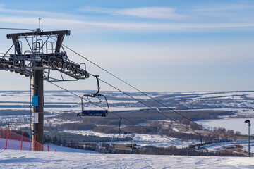 Ski resort in Russia, trails with snow-covered trees and a chairlift, winter day