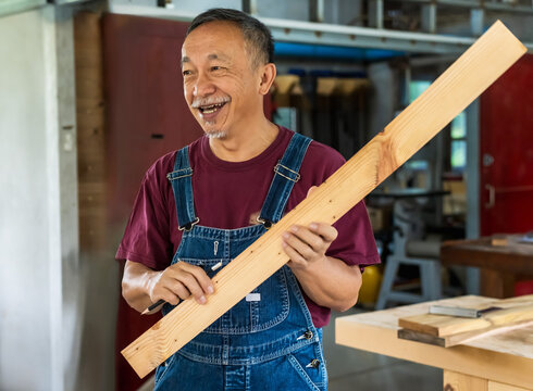 Asian Carpenter man at work in carpentry workshop
