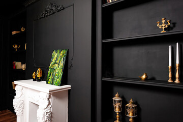 a white fireplace against a black wall with black shelves. A classic Gothic-style photo zone in a...