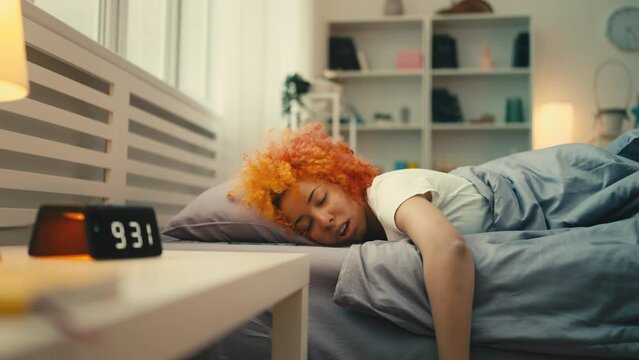 Funny young woman sleeping all morning, procrastination of an unemployed person