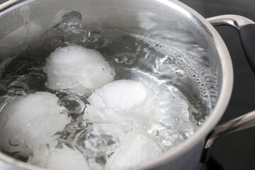 Fototapeta na wymiar Chicken eggs boiling in pot, closeup view
