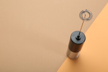 Milk frother wand on color background, above view. Space for text