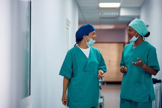 Multiracial female surgeons talking in hallway at hospital.