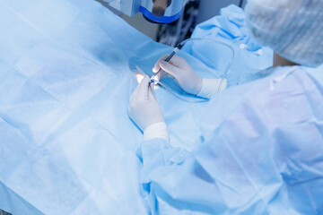 Lasik treatment. Laser vision correction. Doctor examines fundus in microscope, patient under sterile cover.