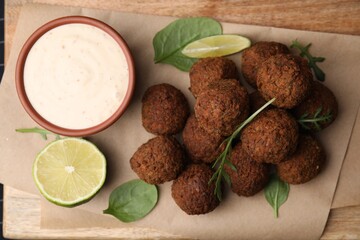 Delicious falafel balls served on wooden table, top view