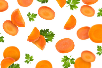 Fresh carrot slices and green parsley falling on white background