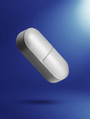 Vitamin pill in air on blue gradient background