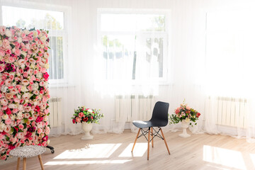 a black chair against the background of open windows. a sunlit photo zone in a photo studio with a...