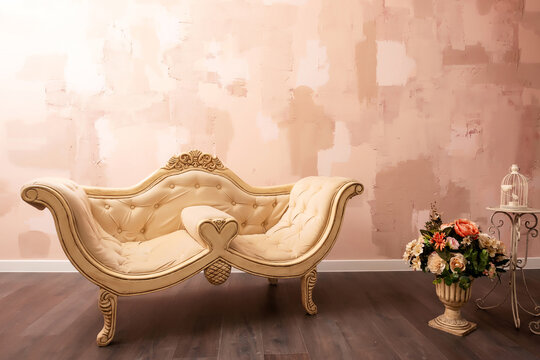 beige sofa on a peach wall background. a ready-made photo zone with a sofa in the photo studio. a piece of furniture on a plain wall