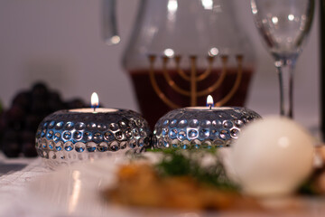Elegant Passover Table Setting: Silver Candle Holder, Red Wine, and Plate on White Tablecloth