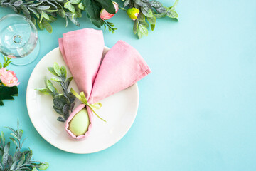 Easter food background, table setting. White plate with cutlery and holiday decorations. Top view...