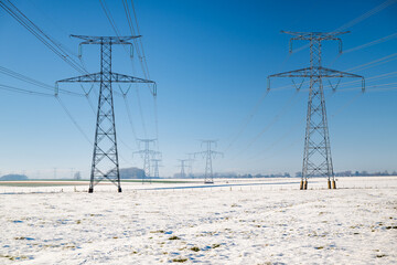 Pylones de ligne à très haute tension en hiver par temps de neige et grand froid  en provenance...