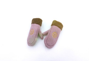 Cute pink winter women's mittens on the snow. Clothes for cold weather wearing.