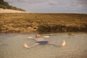 Man swimming and relaxing in natural pool. Immerse Yourself in the Healing Embrace of a Natural Sea...