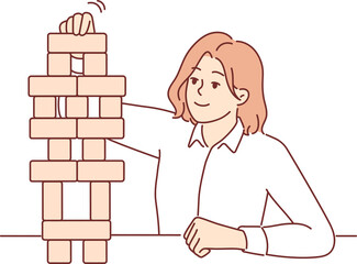 Business woman builds tower of wooden cubes, symbolizing sustainable business strategy and working on development of company. Girl in business clothes plays board game developing concentration.