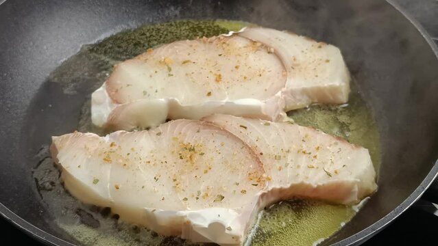 steaks de requin cru, en gros plan, en cuisson dans une po&ecirc;le
