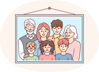 Family photo portrait in frame with teenage children and gray-haired grandparents hangs on wall. Parents and three kids smile to capture happy moments during Sunday get together.