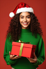 Young excited cool fun woman wear turtleneck Santa hat posing hold present box with gift ribbon bow isolated on studio background.