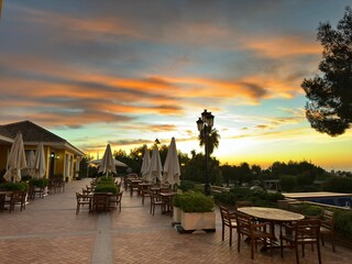 Table chairs and umbrella outdoors before sunset