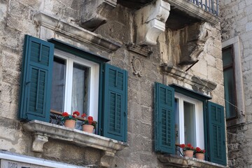 Old residential building with potted flowers near window