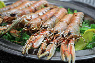 Plate with tasty boiled crayfish and salad on table, closeup