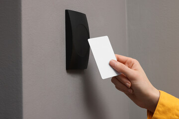 Woman opening magnetic door lock with key card, closeup. Home security