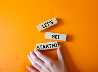 Lets get started symbol. Concept words Lets get started on wooden blocks. Beautiful orange...