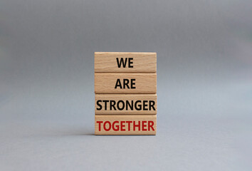 We are stronger together symbol. Wooden blocks with words We are stronger together. Beautiful grey background. We are stronger together concept. Copy space.